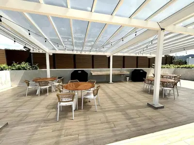 a patio with tables and chairs under a roof at Serene and Modern Beachfront Condo with Ocean Views in Jacó