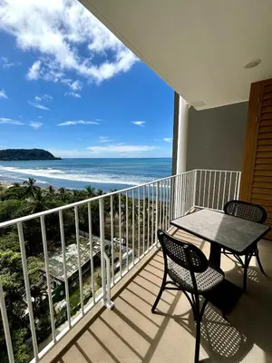 a balcony with a table and chairs and the ocean at Serene and Modern Beachfront Condo with Ocean Views in Jacó