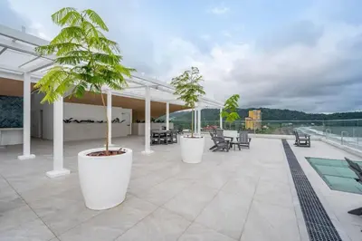 a patio with two potted trees on a roof at Stunning Beachfront 1BR Suite with Ocean View in Jacó