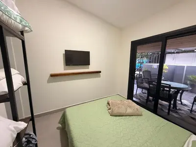 a bedroom with a bed and a flat screen tv at House of the Orange Cat in Coco