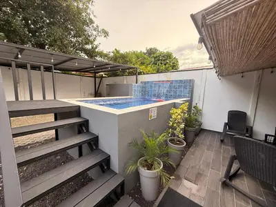 a patio with a deck and a swimming pool at House of the Orange Cat in Coco