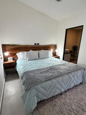 a bedroom with a large bed with a wooden headboard at House of the Orange Cat in Coco