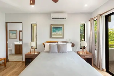 a bedroom with a large bed and two lamps at The Sky Deck Condo 2bed25bath in Coco