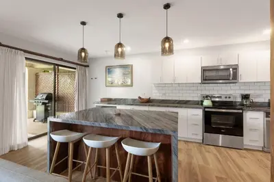 a kitchen with a large counter with stools at The Sky Deck Condo 2bed25bath in Coco