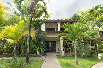 a house with palm trees in front of it at The Sky Deck Condo 2bed25bath in Coco