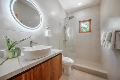 a bathroom with a sink and a toilet and a mirror at Villa Toscana Tamarindo- Elegant villa in Garita
