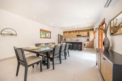 a dining room and kitchen with a table and chairs at Villa Toscana Tamarindo- Elegant villa in Garita
