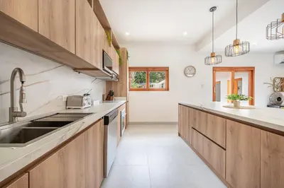 a kitchen with wooden cabinets and a sink at Villa Toscana Tamarindo- Elegant villa in Garita