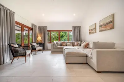 a living room with a couch and chairs and windows at Villa Toscana Tamarindo- Elegant villa in Garita