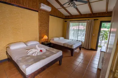 a bedroom with two beds in a room with a window at Pacific Paradise Resort in Quepos