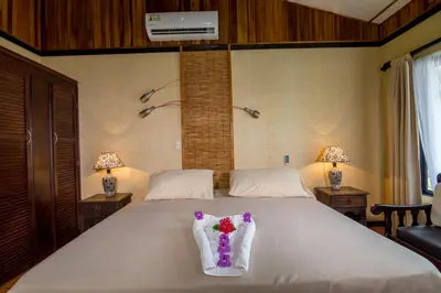 a bedroom with a large white bed with flowers on it at Pacific Paradise Resort in Quepos
