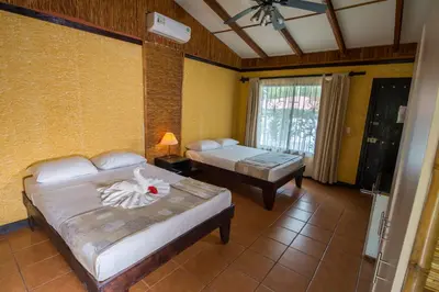 a bedroom with two beds and a window at Pacific Paradise Resort in Quepos