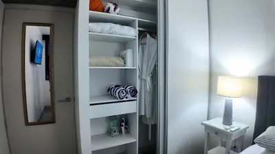 a closet with white shelves and a mirror in a room at Apartment with air conditioning and 20 minutes from the airport in San José