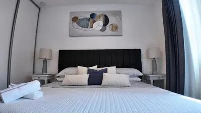 a bedroom with a large bed with two tables at Apartment with air conditioning and 20 minutes from the airport in San José