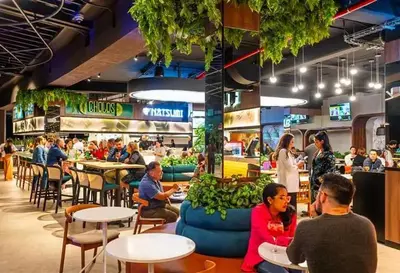 a group of people sitting at tables in a restaurant at Apartment with air conditioning and 20 minutes from the airport in San José