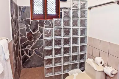 a bathroom with a stone wall at Bahia Azul 3A in Jacó