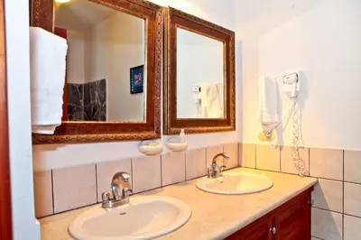 a bathroom with two sinks and a mirror at Bahia Azul 3A in Jacó
