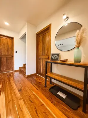 a living room with a mirror and a wooden floor at Casa Nara - Sunset View l Forest Deck - Mountain House in Monteverde Costa Rica