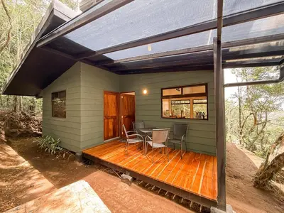 a house with a deck with a table and chairs at Casa Nara - Sunset View l Forest Deck - Mountain House in Monteverde Costa Rica
