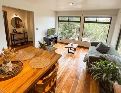 a living room with a table and a couch at Casa Nara - Sunset View l Forest Deck - Mountain House in Monteverde Costa Rica