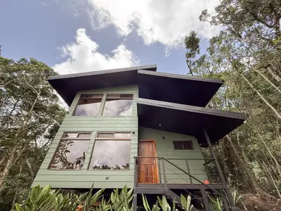a green house with a black roof at Casa Nara - Sunset View l Forest Deck - Mountain House in Monteverde Costa Rica