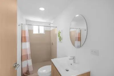 a bathroom with a sink and a toilet and a mirror at Upstay Brand New 3BR Viva Jaco Residences in Jacó