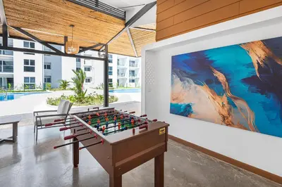 a room with a foosball table and a painting at Upstay Brand New 3BR Viva Jaco Residences in Jacó
