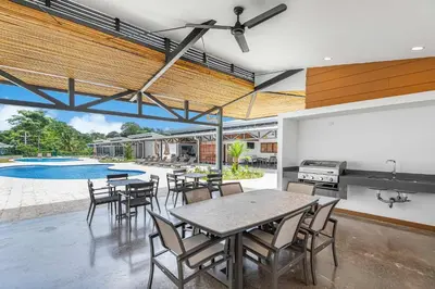 an open kitchen and dining room with a table and chairs at Upstay Brand New 3BR Viva Jaco Residences in Jacó