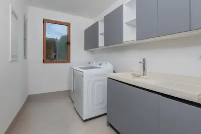 a white bathroom with a sink and a washing machine at Salty Living - Tamarindo Hills in Tamarindo