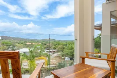 a room with a table and chairs and a large window at Salty Living - Tamarindo Hills in Tamarindo
