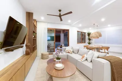 a living room with a white couch and a tv at Salty Living - Tamarindo Hills in Tamarindo