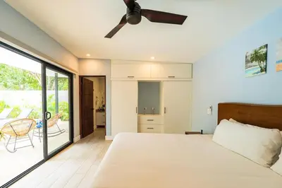 a bedroom with a bed and a ceiling fan at Serenity Surf Villa in Playa Grande