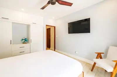 a bedroom with a bed and a ceiling fan at Serenity Surf Villa in Playa Grande