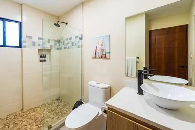a bathroom with a toilet and a sink and a shower at Serenity Surf Villa in Playa Grande