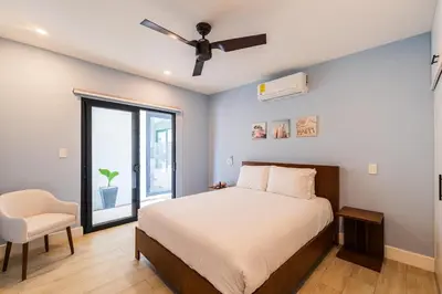 a bedroom with a bed and a ceiling fan at Serenity Surf Villa in Playa Grande