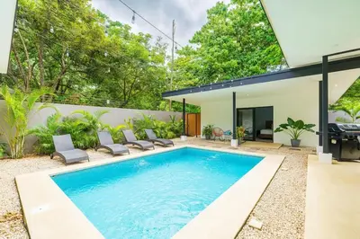 a swimming pool in the backyard of a house at Serenity Surf Villa in Playa Grande
