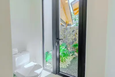 a bathroom with a toilet and a sliding glass door at Casa Nimbu - Hacienda Pinilla in Tamarindo