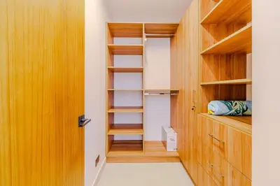 a walk in closet with wooden shelves and a door at Casa Nimbu - Hacienda Pinilla in Tamarindo