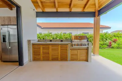 an outdoor kitchen with a stainless steel refrigerator at Casa Nimbu - Hacienda Pinilla in Tamarindo