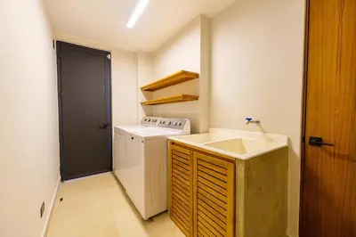 a small kitchen with a sink and a washing machine at Casa Nimbu - Hacienda Pinilla in Tamarindo