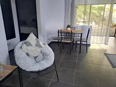 a living room with a table and a chair at Costa Verde Retreat 1 - Ground Floor in Quepos