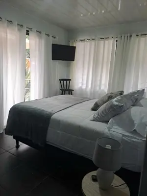 a bedroom with a large bed with white curtains at Costa Verde Retreat 2 - Upper Floor in Quepos