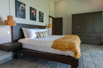 a bedroom with a large bed with a brown blanket at Villa Ballena-luxury Ocean view in Uvita