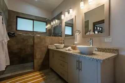 a bathroom with two sinks and a shower at Villa Ballena-luxury Ocean view in Uvita