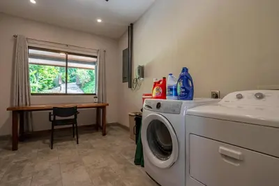 a laundry room with a washing machine and a table at Villa Ballena-luxury Ocean view in Uvita