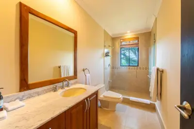 a bathroom with a sink and a toilet and a mirror at Malinche 422B- Ocean view condo at Reserva Conchal in Brasilito