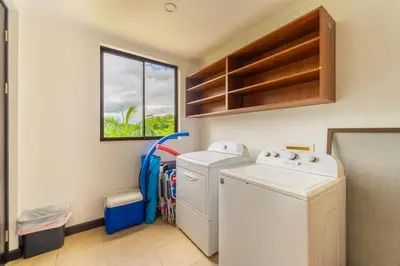 a laundry room with a washer and dryer and a window at Malinche 422B- Ocean view condo at Reserva Conchal in Brasilito
