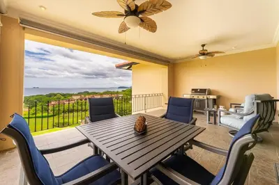 a dining room with a table and chairs and a balcony at Malinche 422B- Ocean view condo at Reserva Conchal in Brasilito