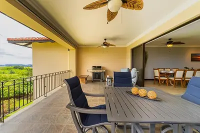 a dining room with a table and chairs on a balcony at Malinche 422B- Ocean view condo at Reserva Conchal in Brasilito