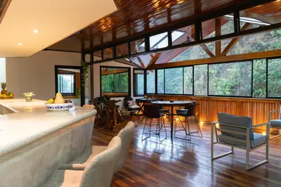 a large room with a bar with chairs and tables at Casa Coyota Hotel in Monteverde Costa Rica